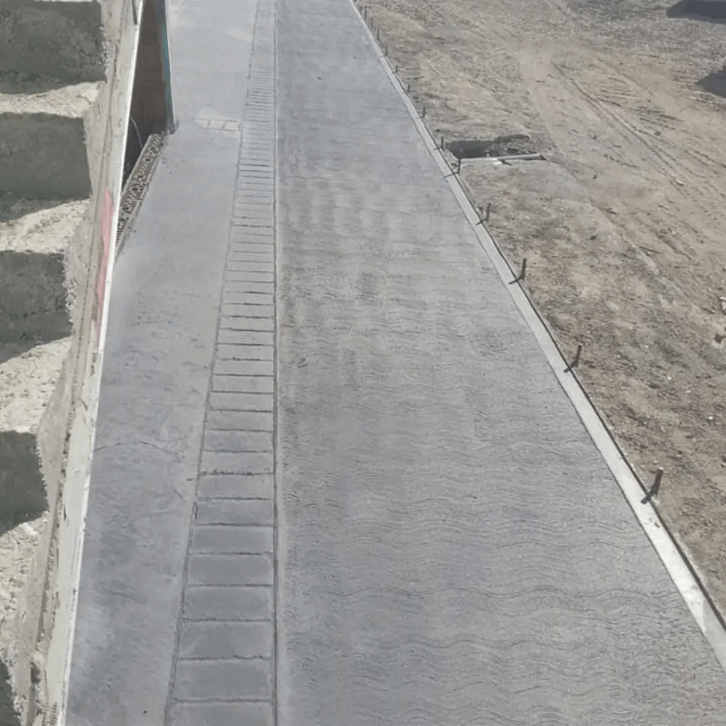 Trotuar din beton periat gri realizat lângă casă cu finisaj modern și margini precise de Rbeton
