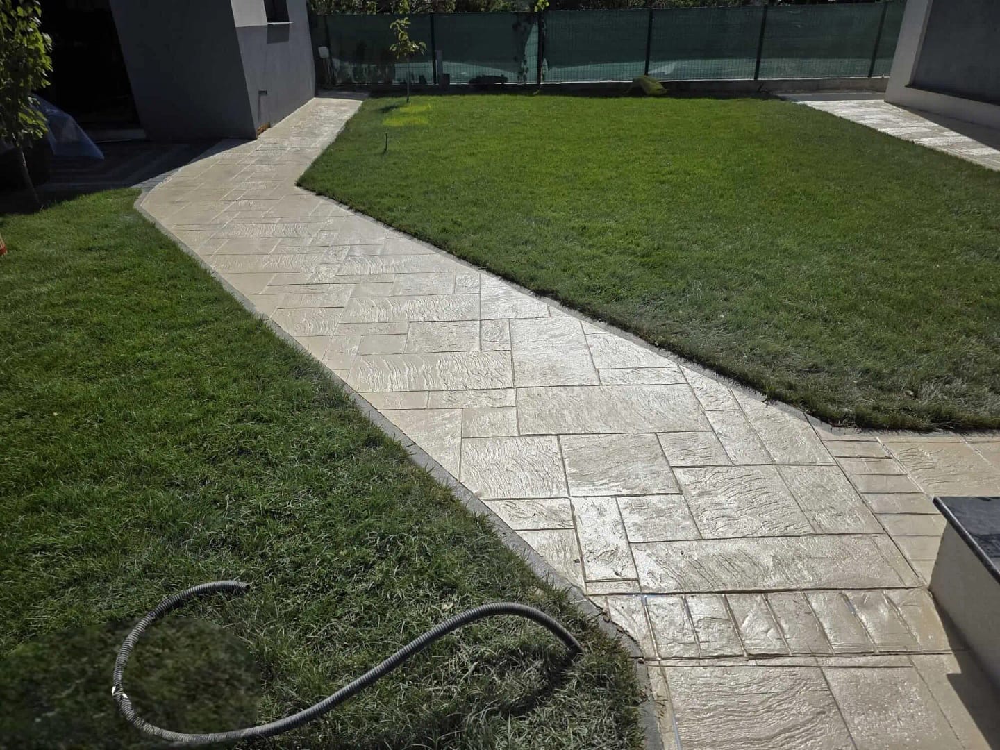 Alee de grădină din beton amprentat bej cu traseu elegant prin gazon realizată de RBETON